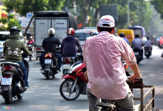 
Trên đường 3/2 (quận 10), mồ hôi ướt đẫm áo người đàn ông đạp chiếc xe ba gác thu mua đồ cũ.
