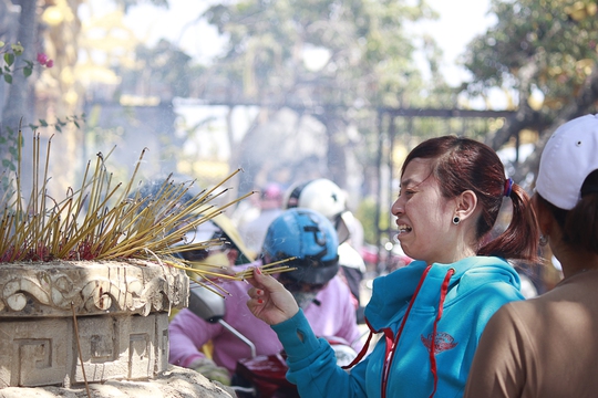 
Một người phụ nữ tỏ vẻ khó chịu khi không tìm được chỗ cắm nhang và khói hương bay nghi ngút tới mức khó thở.
