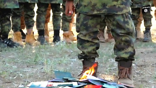
Những đứa trẻ ném hộ chiếu xuống đất và châm lửa, ngụ ý mãi mãi trung thành với IS. Ảnh: DAILY MAIL

 
