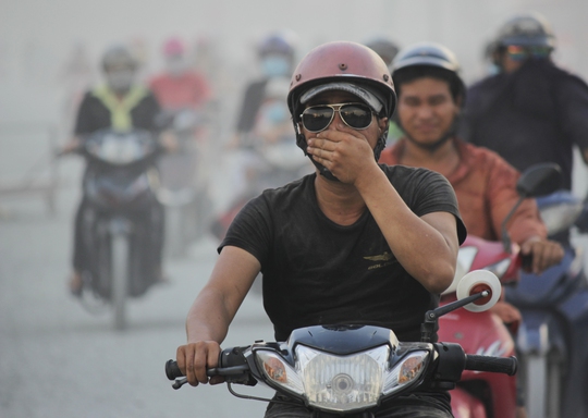 
Người nào không trang bị khẩu trang đành phải một tay loạng choạng lái xe, tay kia đưa lên bịt mũi hoặc kéo áo che mặt lại để tránh bụi.
