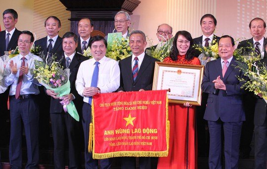 Ông Lê Thanh Hải (bìa phải), Ủy viên Bộ Chính trị - Chỉ đạo Đảng bộ TP HCM, trao danh hiệu Anh hùng Lao động cho lãnh đạo LĐLĐ TP các thời kỳ Ảnh: HOÀNG TRIỀU