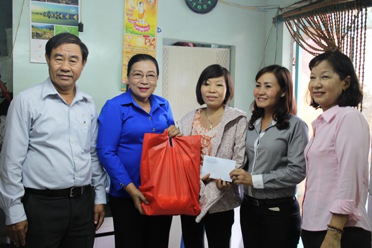 Bà Nguyễn Thị Bích Thủy (thứ hai bên trái), Phó Chủ tịch LĐLĐ TP HCM, tặng quà Lê Thị Khánh Toàn Ảnh: HỒNG ĐÀO