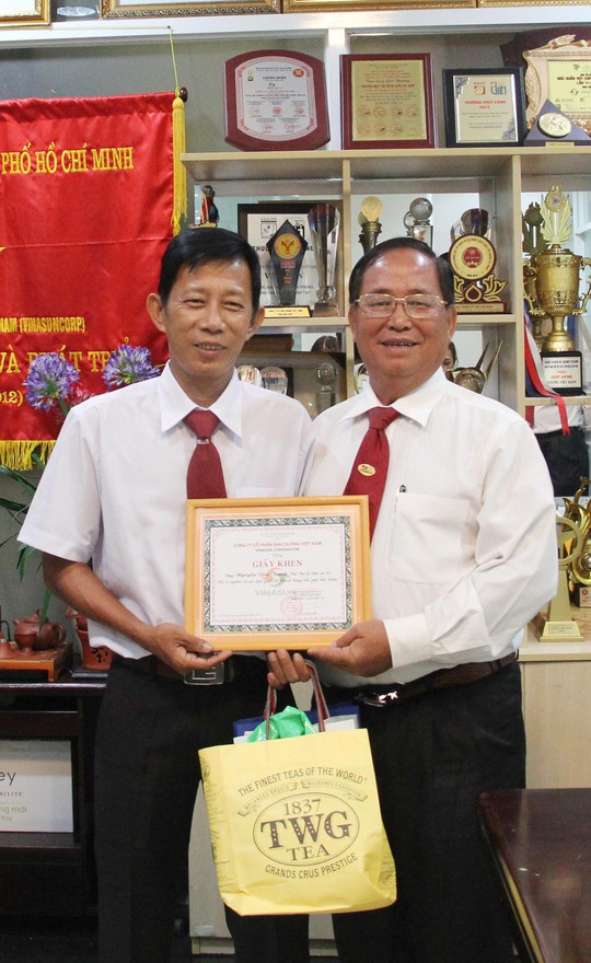 Ông Tạ Long Hỷ (bìa phải), Phó Tổng giám đốc Vinasun, trao giấy khen và tiền thưởng cho tài xế Nguyễn Văn Thanh