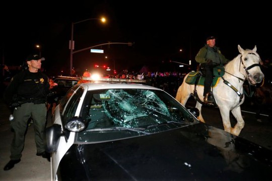
Một xe cảnh sát bị đập vỡ kính. Ảnh: Reuters
