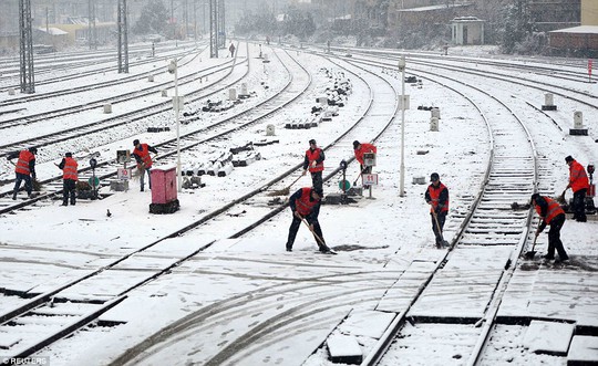 Công nhân dọn tuyết trên đường ray xe lửa ở TP Nam Xương, tỉnh Giang Tây. Ảnh: Reuters
