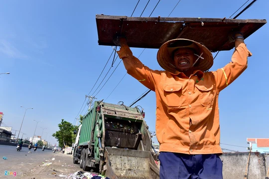 
Ông Nguyễn Thanh Sơn (quận 12) đóng tấm cửa xe kết thúc chuyến thu gom và giao rác tại điểm tập kết trên Quốc lộ 1, quận 12 sau những giờ làm việc giữa nắng.
