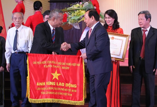 Ông Lê Thanh Hải, Ủy viên Bộ Chính trị, Chỉ đạo Đảng bộ TP HCM, trao cờ Anh hùng Lao động thời kỳ đổi mới cho lãnh đạo tổ chức CĐ các thời kỳ ẢNH: HOÀNG TRIỀU