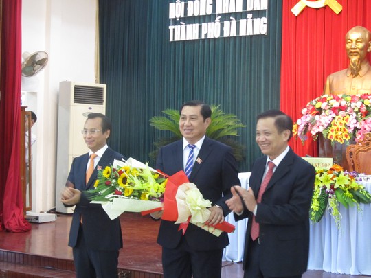 Ông Nguyễn Xuân Anh (trái), bí thư, chủ tịch HĐND TP Đà Nẵng và nguyên Chủ tịch HĐND TP Đà Nẵng Trần Thọ (phải) tặng hoa chúc mừng Chủ tịch UBND TP Huỳnh Đức Thơ (giữa) tái đắc cử