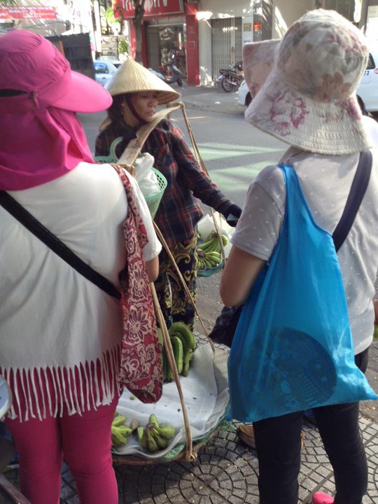 Nhóm khách Trung Quốc vây quanh không cho chị bán chuối tiếp tục đi