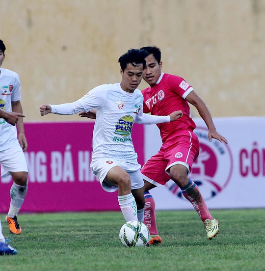 Cầu thủ Hà Nội (phải) tranh bóng với Văn Toàn trong trận thua HAGL 0-5 ở vòng 1