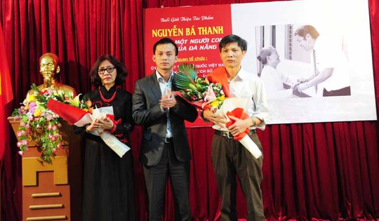 Ông Nguyễn Bá Cảnh (giữa) tặng hoa cho tác giả Kim Thành (bìa trái) tại lễ ra mắt sách