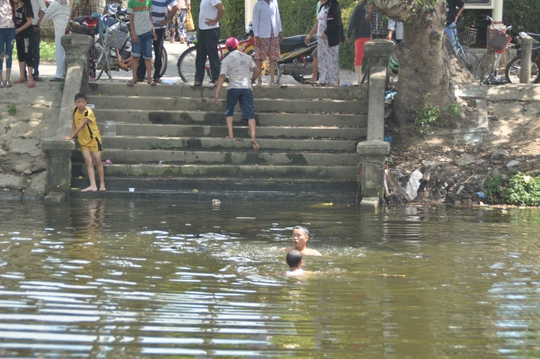 Người dân lặn xuống sông Phổ Lợi (xã Phú Dương, huyện Phú Vang, tỉnh Thừa Thiên - Huế) tìm kiếm 3 trẻ bị đuối nước
