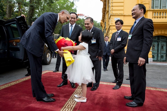 
Tổng thống Obama cúi xuống nhận hoa và cảm ơn em bé tặng hoa khi bắt đầu Lễ đón Chính thức tại Phủ Chủ tịch sáng 23-5
