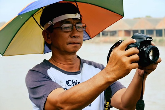 Nhiếp ảnh gia Phạm Thiết Mẫn tác nghiệp trên trường quay. (Ảnh do nhân vật cung cấp)