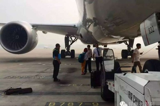 
Người phụ nữ cố thuyết phục nhân viên sân bay để được lên máy bay. Ảnh: China Daily
