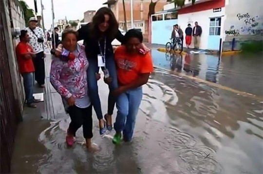 
Nữ phóng viên Lydia Cummings được người dân khiêng qua một con đường ngập nước ở TP Puebla. Ảnh: CEN
