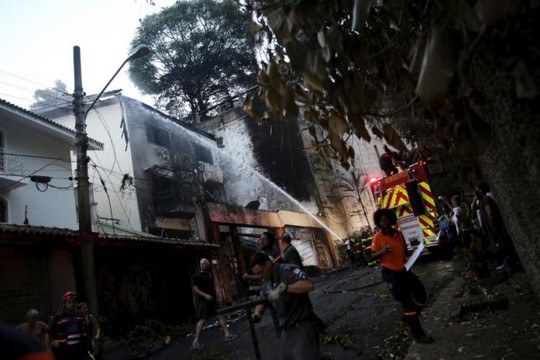 Cứu hỏa chữa lửa do máy bay đâm xuống hai tòa nhà gây ra. Ảnh: Reuters