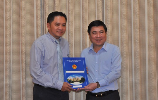 
Chủ tịch UBND TP Nguyễn Thành Phong (bìa phải) trao quyết định bổ nhiệm ông Phạm Huy Bình giữ chức Chủ tịch Hội đồng thành viên Saigontourist
