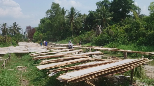 
Phơi thành phẩm ngoài đường cạnh rác thải, cống nước thải ô nhiễm.
