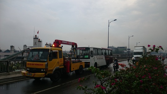 
Xe cứu hộ giải cứu một xe buýt bị chết máy vì mưa ngập trên cầu Rạch Chiếc.

