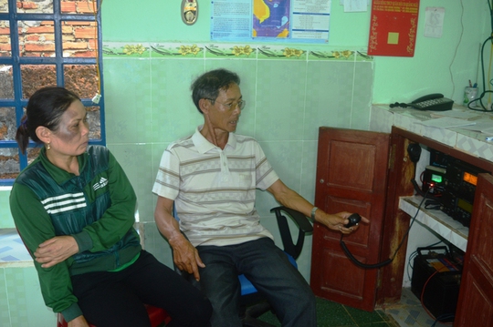 Bà Nguyễn Thị Năng, vợ ngư dân Võ Văn Lựu ngồi bên máy icom cộng đồng chờ tin tức. Ảnh: T.Trực
