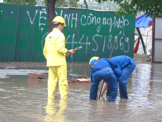 
nhân viên thoát nước mở cống trên đường Phạm Hùng để thoát nước.
