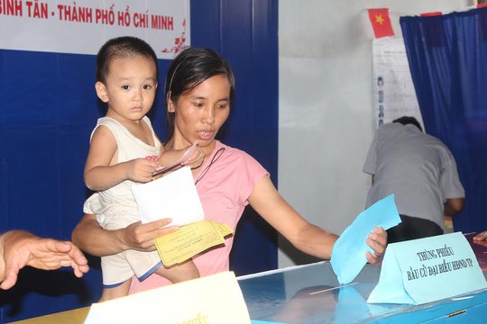 
Nữ công nhân Nguyễn Thị Tuyết đưa con đi bầu cử
