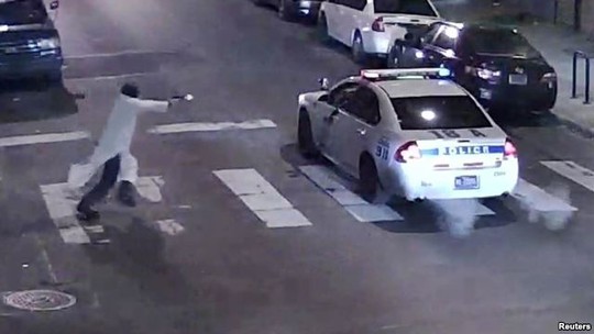 
Hình ảnh chụp lại trong video do camera giám sát quay được cho thấy kẻ tấn công lao đến bắn vào xe cảnh sát
