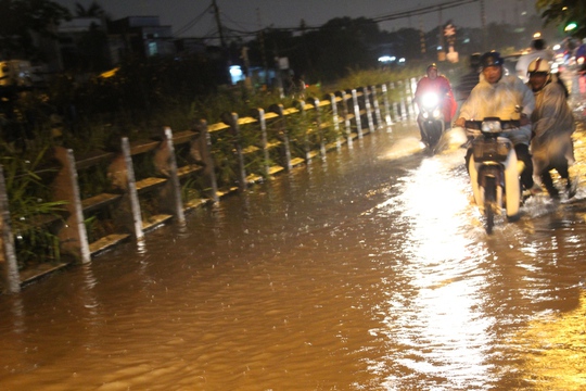 
Tại khu vực quận Gò Vấp, nước ngập từ đường ray xe lửa tràn qua tuyến đường bộ kế bên trong cơn mưa chiều 26-8

