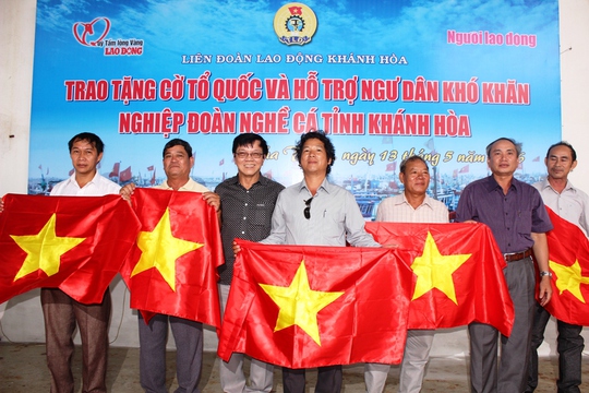 
Ông Nguyễn Hòa và Nguyễn Văn Tín, Phó Tổng Biên tập Báo Người Lao Động trao cờ cho đại diện các nghiệp đoàn nghề cá Khánh Hòa
