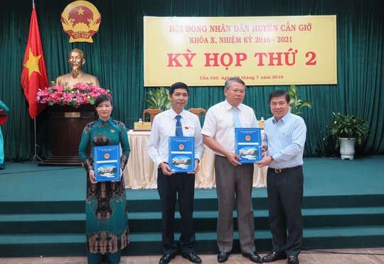 
Chủ tịch UBND TP Nguyễn Thành Phong (bìa phải) trao quyết định phê chuẩn các chức danh lãnh đạo huyện Cần Giờ
