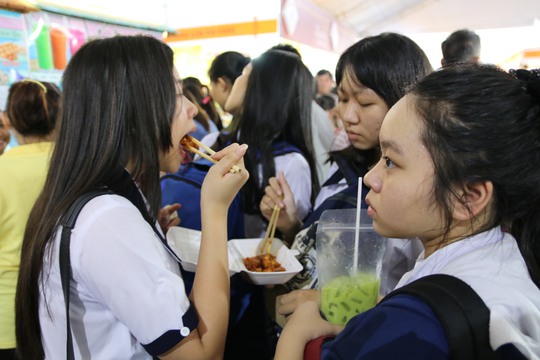 Một nhóm học sinh vừa mua món gỏi Thái, trà sữa Thái chia nhau để thưởng thức trong khu cảnh chen chút.