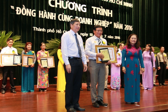 Ông Trần Thanh Hải, Phó Chủ tịch Thường trực Tổng LĐLĐ Việt Nam và bà Nguyễn Thị Lệ, Trưởng Ban Dân vận Thành ủy, tặng hoa và biểu trưng cho chủ doanh ngihệp điển hình Ảnh: KHÁNH LINH