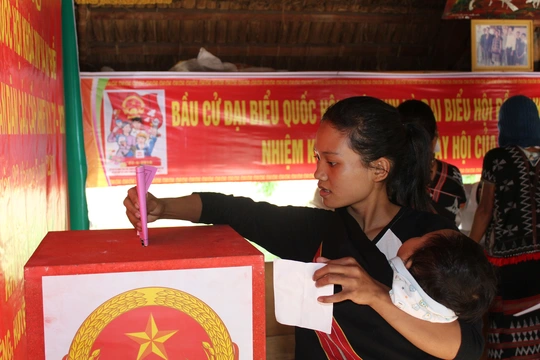 
Cử tri tại huyện miền núi Tây Giang, tỉnh Quảng Nam địu con đi bầu cử sáng 22-5
