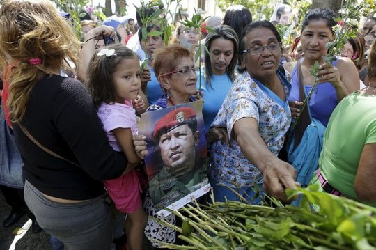 Những người ủng hộ Tổng thống Maduro đặt hoa trước di ảnh cố tổng thống Hugo Chavez. Ảnh: REUTERS