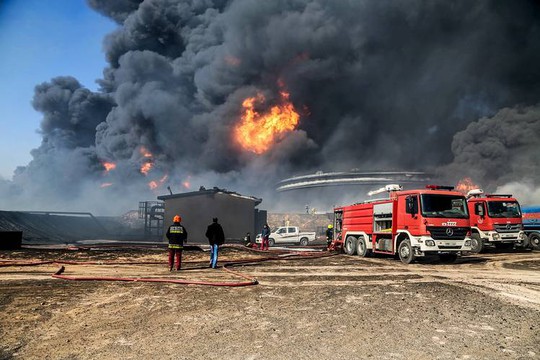 Lính cứu hỏa cố gắng dập tắt đám cháy ở Es Sider hồi tuân trước. Ảnh: REUTERS