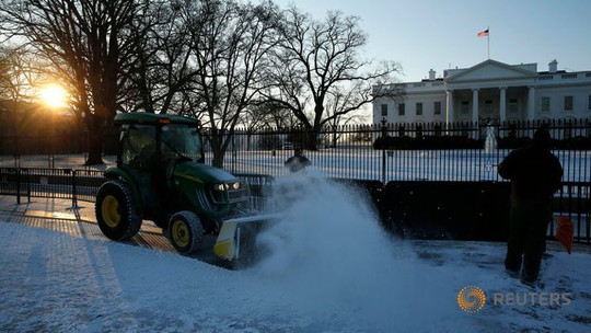 Xe dọn tuyết trên vỉa hè trước Nhà Trắng hôm 21-1. Ảnh: Reuters