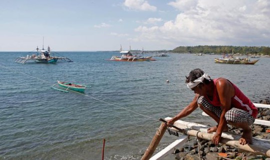 
Ngư dân Philippines sửa tại tàu dùng để đánh cá tại vùng biển quanh Scarborough. Ảnh: REUTERS
