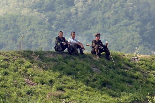 
Binh lính Triều Tiên ngồi ở khu vực gần TP Sinuiju, gần TP Đan Đông của Trung Quốc. Ảnh: UPI
