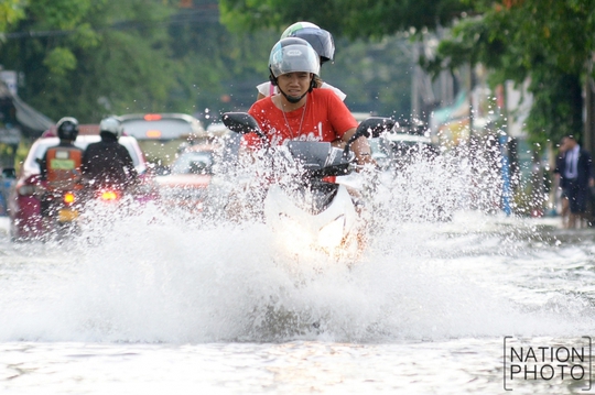 
Người dân chạy trên đường phố ngập nước ở quận Chatuchak hôm 20-6. Ảnh: Nation
