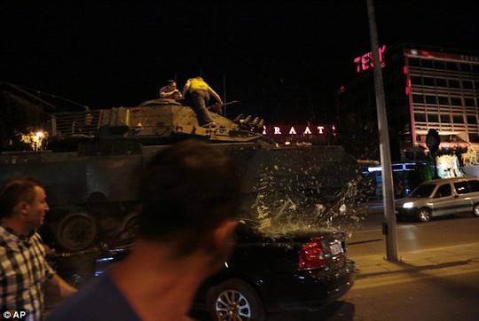 Một xe tăng quân đội ở trung tâm Ankara trườn lên ô tô khi người biểu tình cố ngăn nó di chuyển. Ảnh: AP