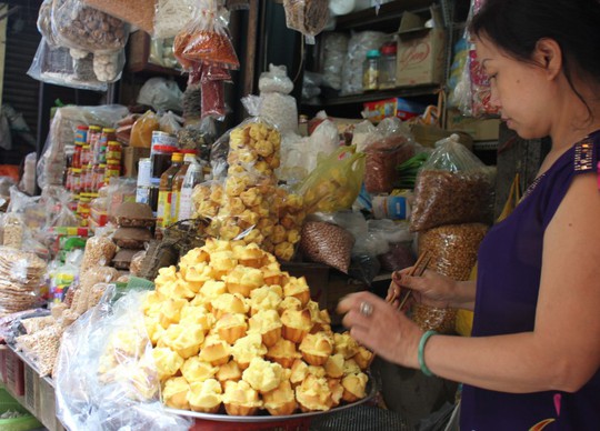 
			Chị Xinh, quê ở Quảng Nam vào Sài Gòn lập nghiệp và bán hàng ở Chợ Bà Hoa hơn 20 năm. Những chiếc bánh Thuẫn thơm ngon được bày bán tại quầy của chị Xinh có giá 2.500 đồng/cái
			