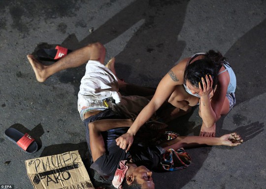
Một người vợ than khóc bên xác chồng ở TP Pasay, phía Nam Manila. Ảnh: EPA
