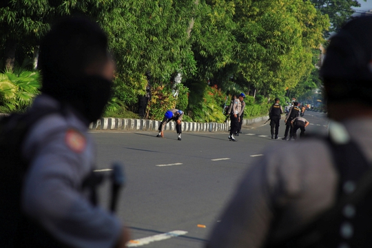 Cảnh sát thu thập các mảnh bom tại hiện trường vụ tấn công ở Indonesia Ảnh: Reuters