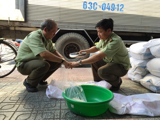 
Cán bộ quản lý thị trường lấy mẫu gạo chứa trong bao bì có nhãn hiệu nước ngoài để kiểm nghiệm
