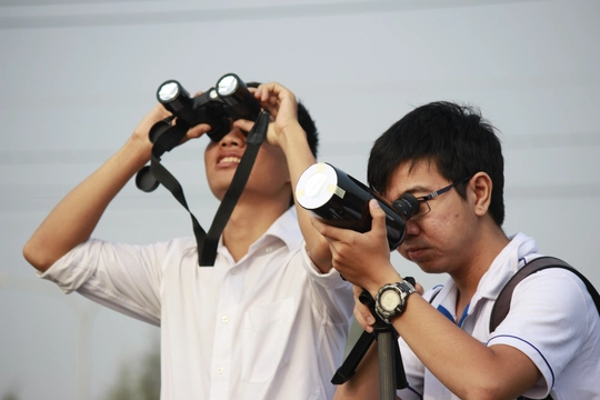 
Một số người chuẩn bị các trang thiết bị hiện đại có gắn kiếng lọc để quan sát rõ hơn hiện tượng nhật thực ngày 9-3
