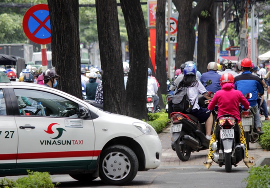 Không chỉ có xe máy, taxi cũng tấp vào vỉa hè chờ bớt kẹt xe để đi tiếp.