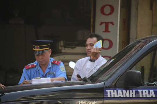 
Một tài xế taxi ngơ ngác khi bị phạt lỗi đậu xe dưới lòng đường Lê Hồng Phong (quận 5)
