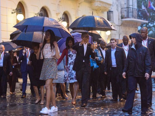 ...và cả nhà tham quan quảng trường Cathedral ở Havana trong cơn mưa nặng hạt. Ảnh: USA TODAY