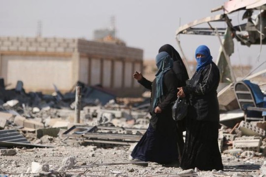 
Phụ nữ ở Syria bước đi trên đống đổ nát ở thị trấn al-Shadadi thuộc tỉnh Hasaka ngày 26-2. Ảnh: Reuters
